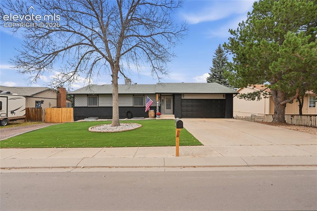 Caption: Single-story residence featuring a two-tone exterior, an attached garage, a paved driveway, and a ma