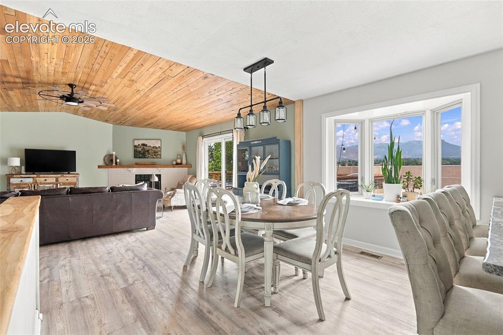Image 12 of 49: Open-concept living space featuring wood-finish flooring, a wood plank vaul