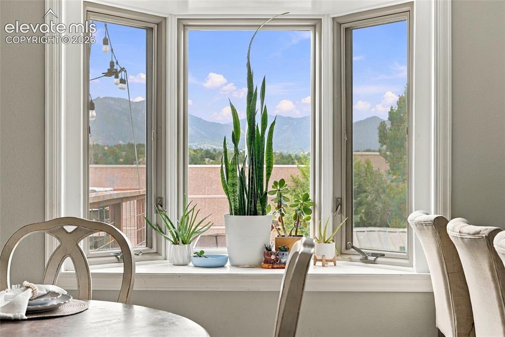 Image 16 of 49: Bay window with mountain scenery and white trim