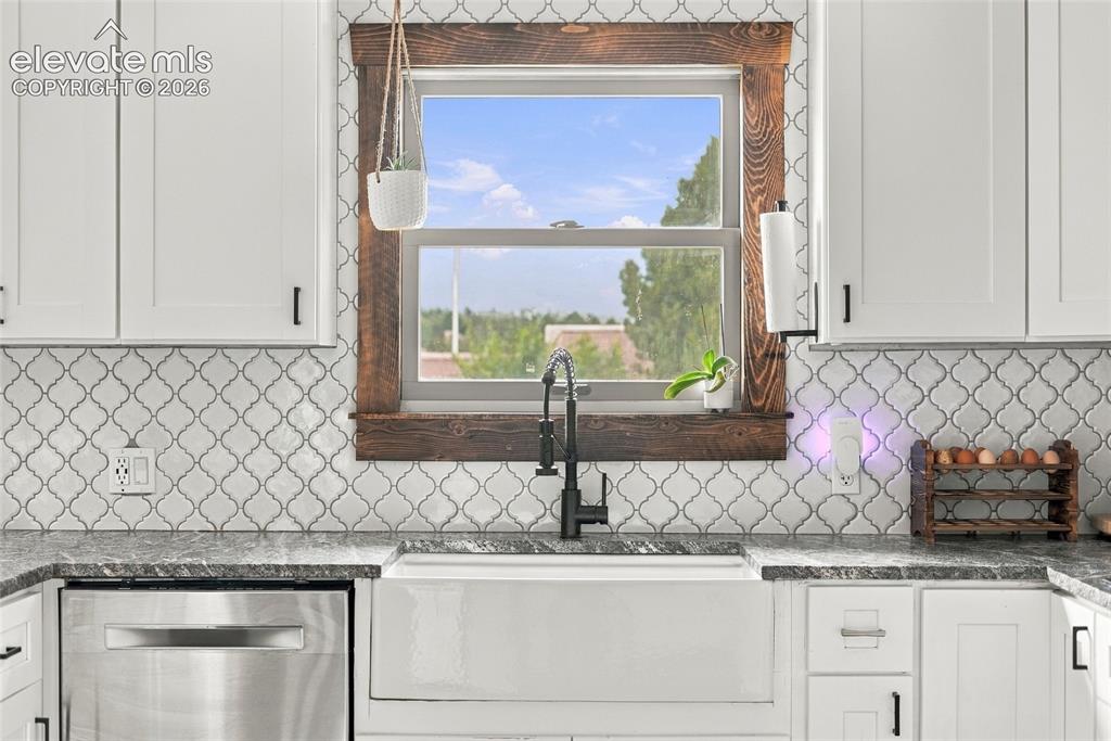 Image 19 of 49: White shaker cabinetry with matte black hardware, arabesque tile backsplash