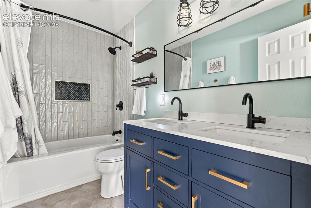 Image 24 of 49: Dual-sink vanity with matte black faucets and a white countertop, blue cabi