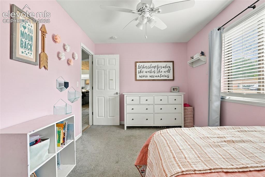Image 26 of 49: White five-panel interior door, ceiling fan with light fixture, window with