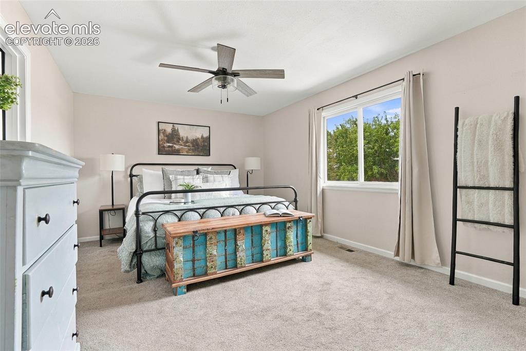 Image 27 of 49: Neutral wall color, ceiling fan, window with white trim, and light-colored 