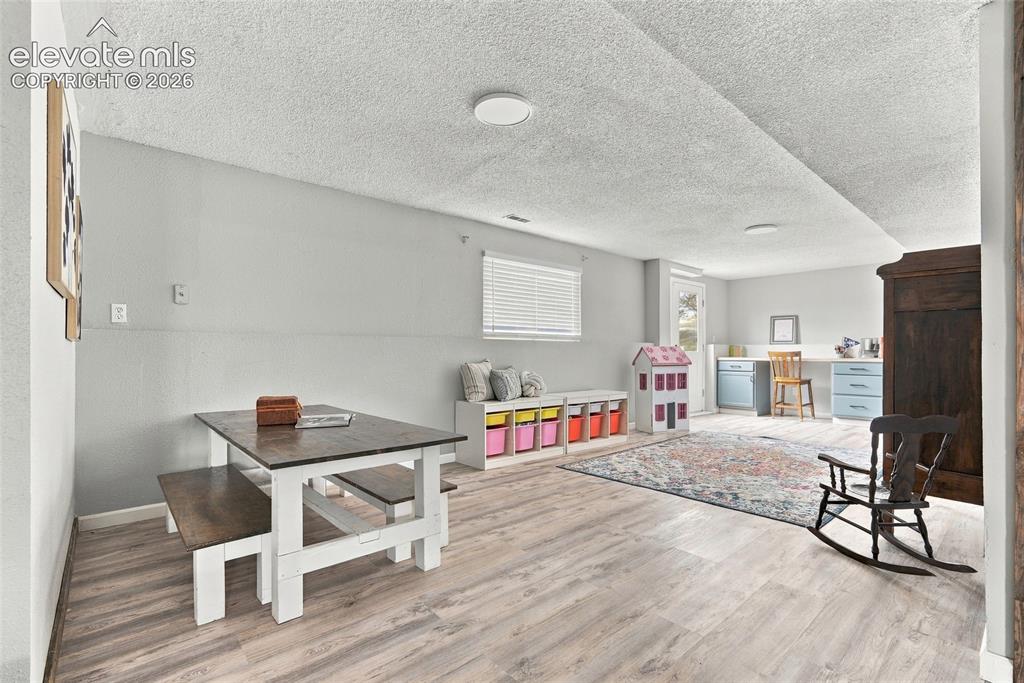 Image 33 of 49: Light-toned wood-finish flooring, recessed lighting, white window blinds, l
