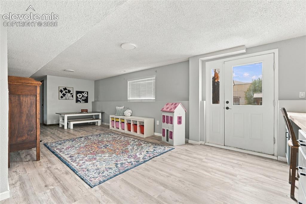 Image 35 of 49: Light wood-finish flooring, recessed lighting, and a window with blinds