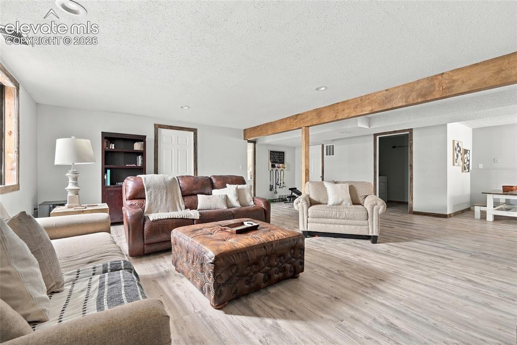 Image 36 of 49: Recessed lighting, wood-finish flooring, wood-framed window, exposed wood b