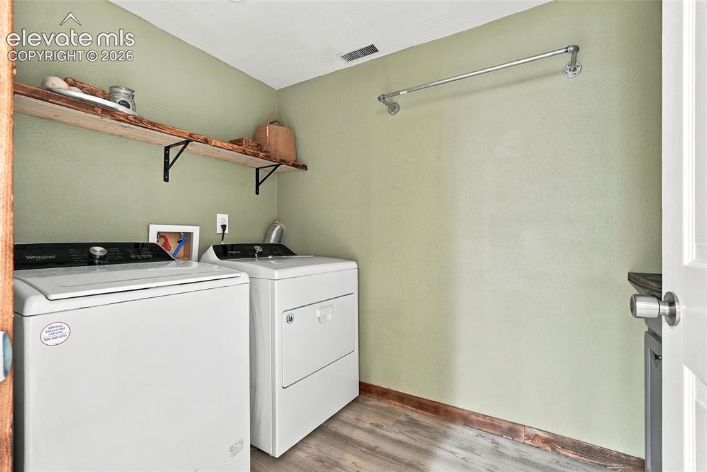 Image 38 of 49: Light green walls complement wood-finish flooring