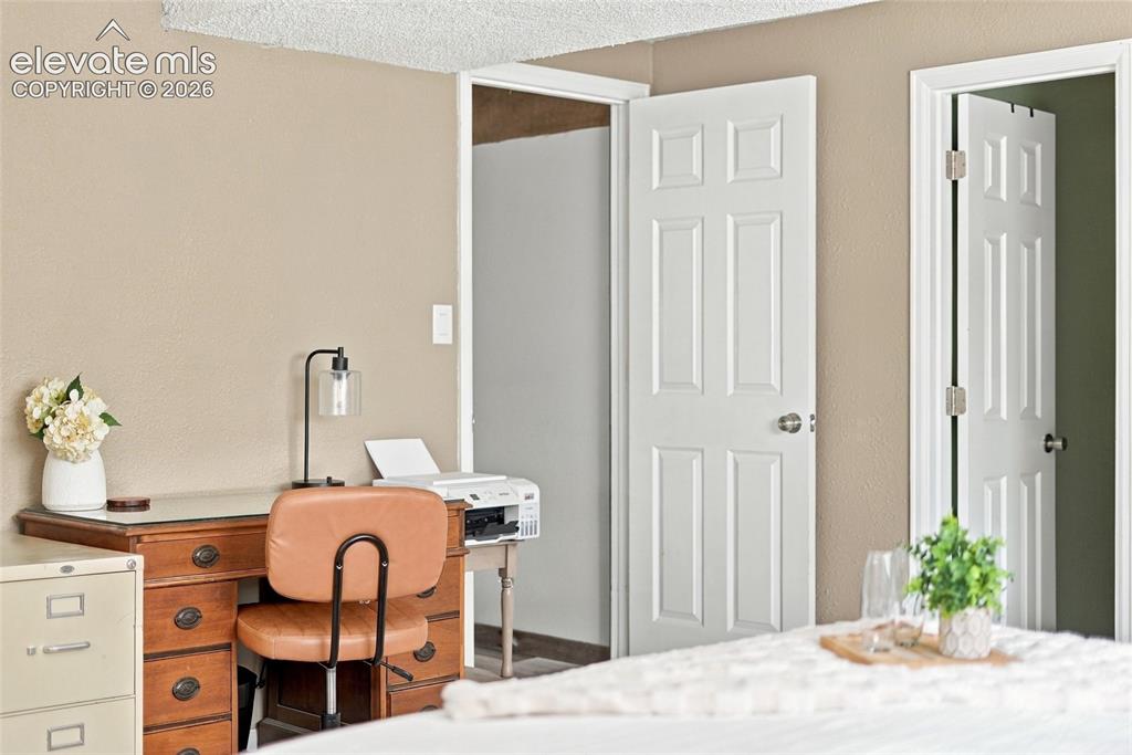 Image 43 of 49: Neutral wall color, white six-panel doors, white trim, and textured ceiling