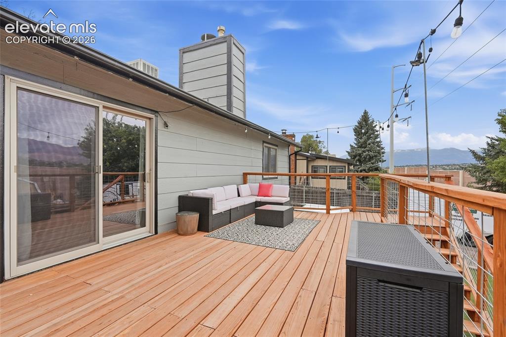 Image 44 of 49: Spacious deck featuring wood decking, a cable railing system, and a sliding