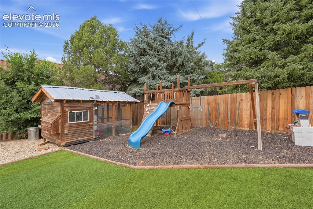 Image 48 of 49: Backyard featuring a wooden privacy fence, well-maintained artificial turf,