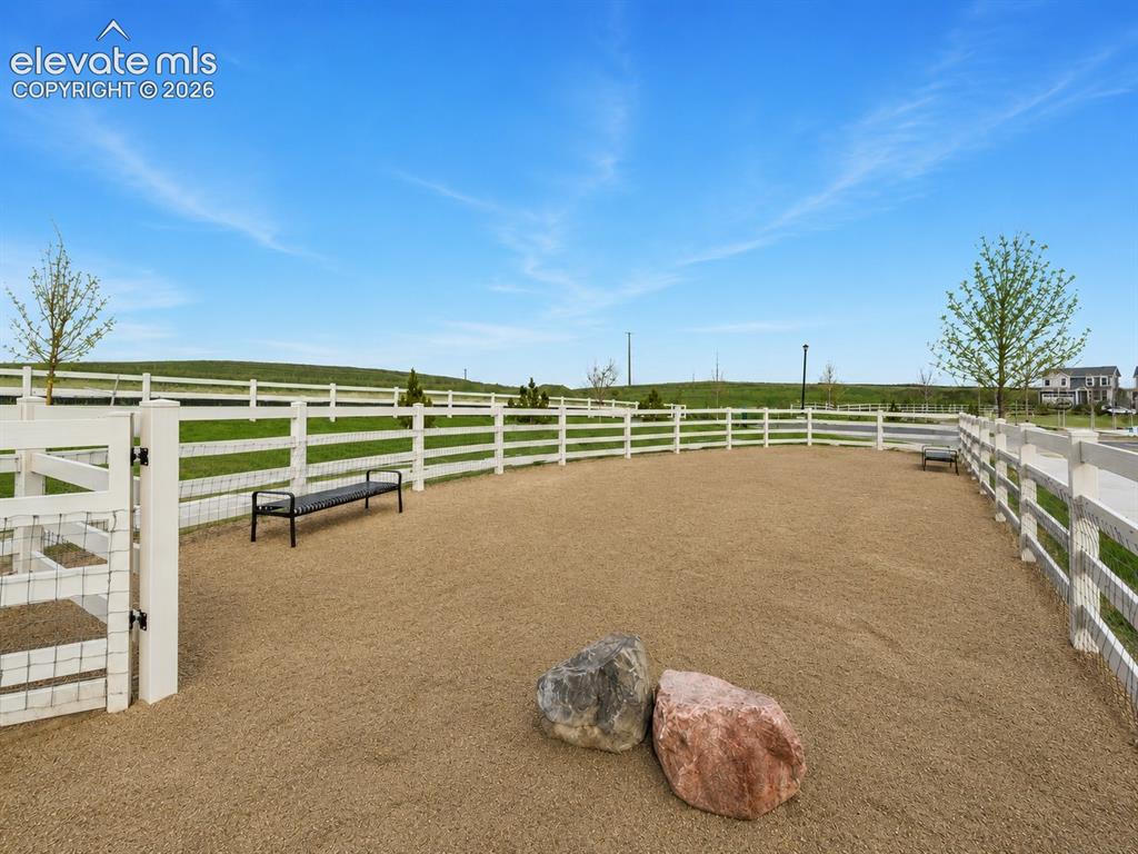 Image 24 of 45: Fenced outdoor area featuring a gravel surface, white fencing, and integrat