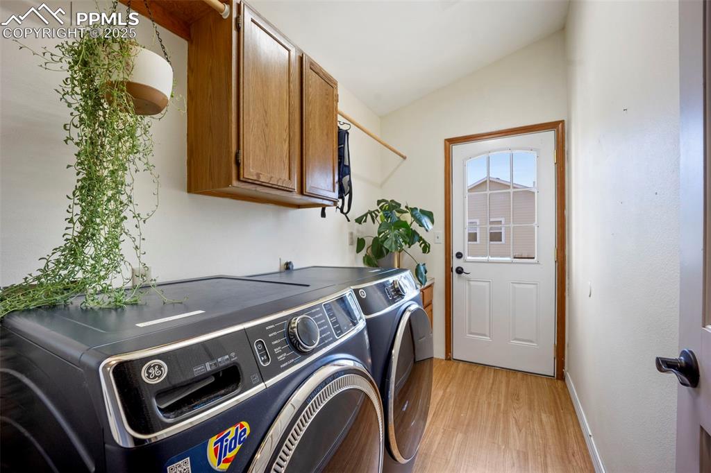 Image 35 of 50: Laundry room with light wood finished floors, separate washer and dryer, ca