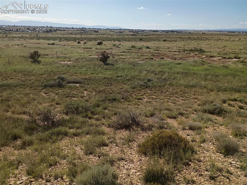 Image 7 of 10: Aerial view of sparsely populated area featuring a mountain backdrop