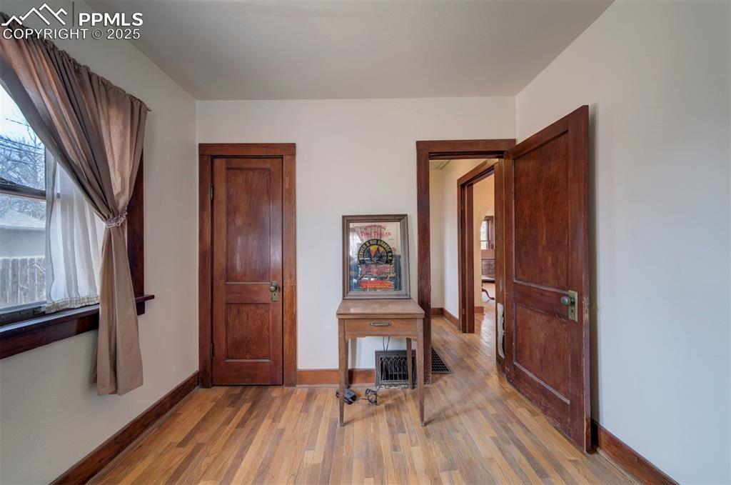 Image 33 of 40: View from back bedroom to closet and hall to bathroom