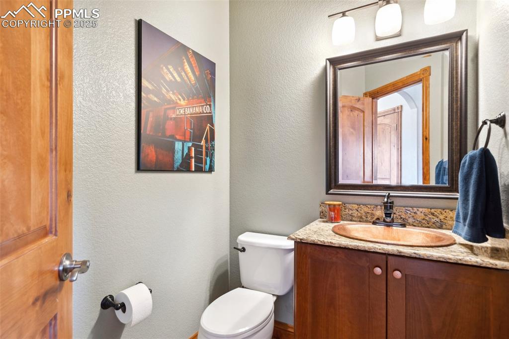 Image 16 of 46: Bathroom featuring toilet, vanity, and a textured wall