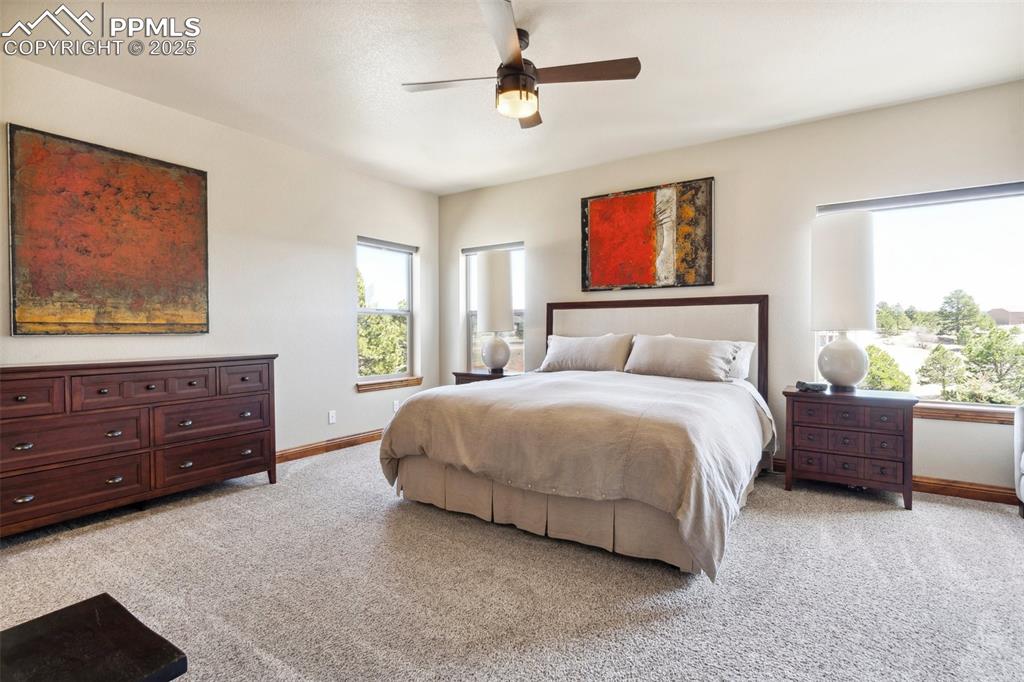 Image 17 of 46: Bedroom featuring baseboards, ceiling fan, and light carpet