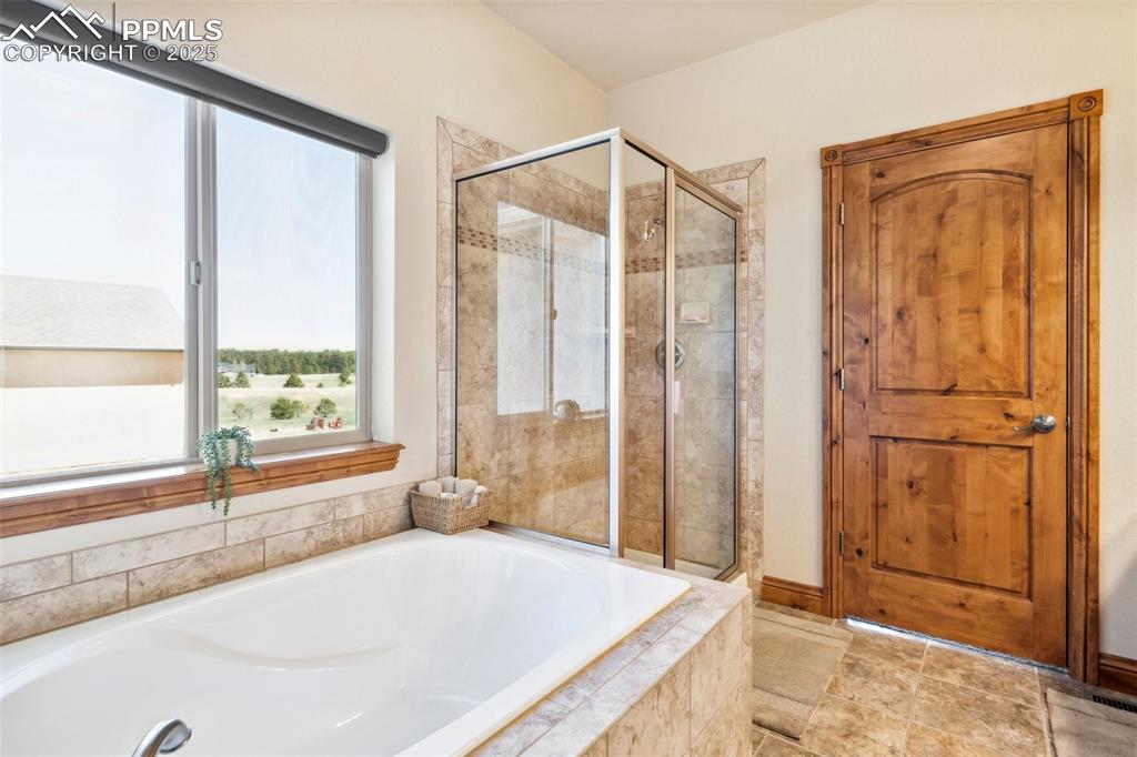 Image 21 of 46: Bathroom with a bath and a shower stall