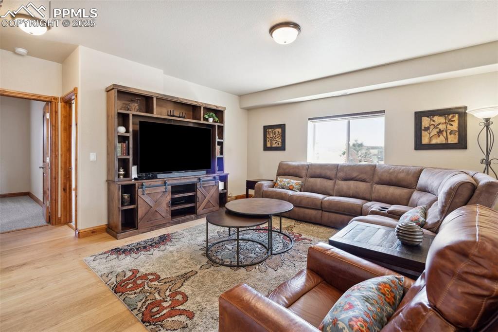 Image 23 of 46: Living area with baseboards and wood finished floors