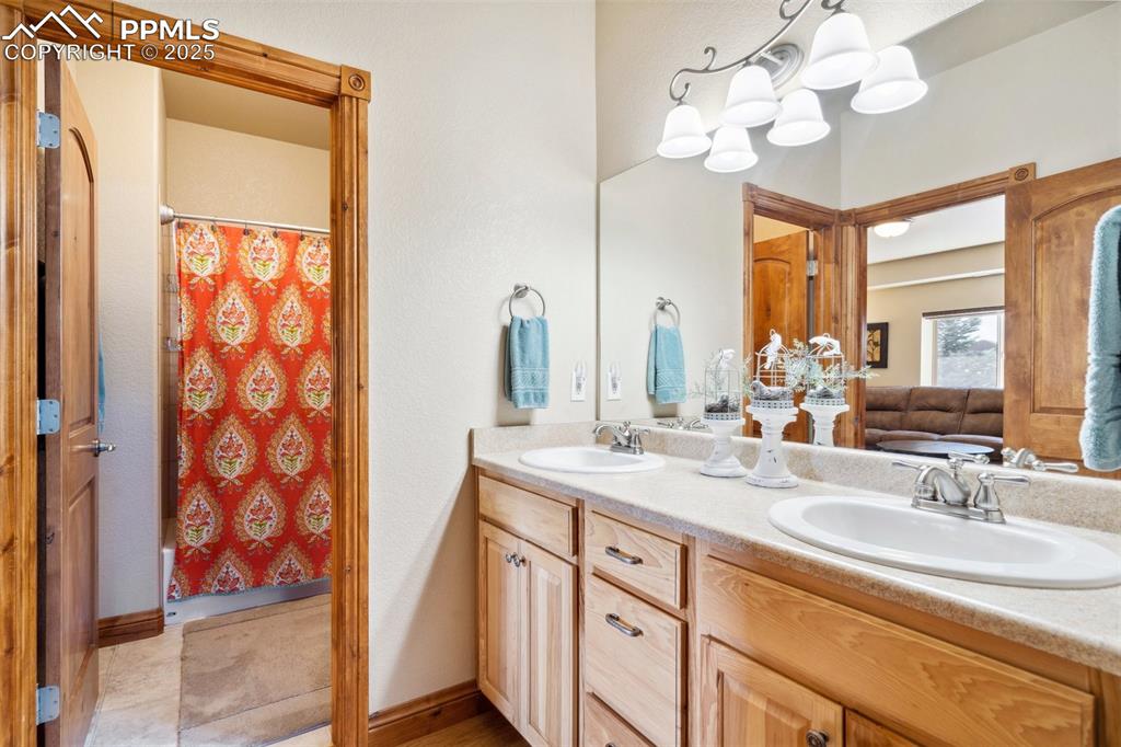 Image 31 of 46: Bathroom featuring double vanity, a sink, and a shower with curtain