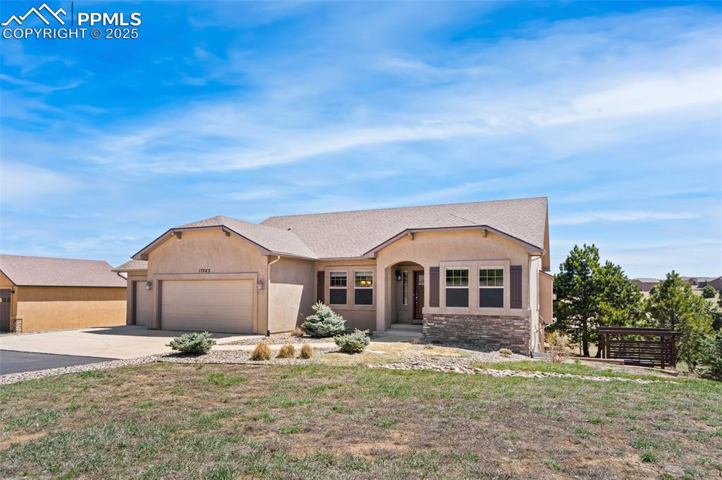Image 32 of 46: Ranch-style home featuring an attached garage, driveway, and stucco siding