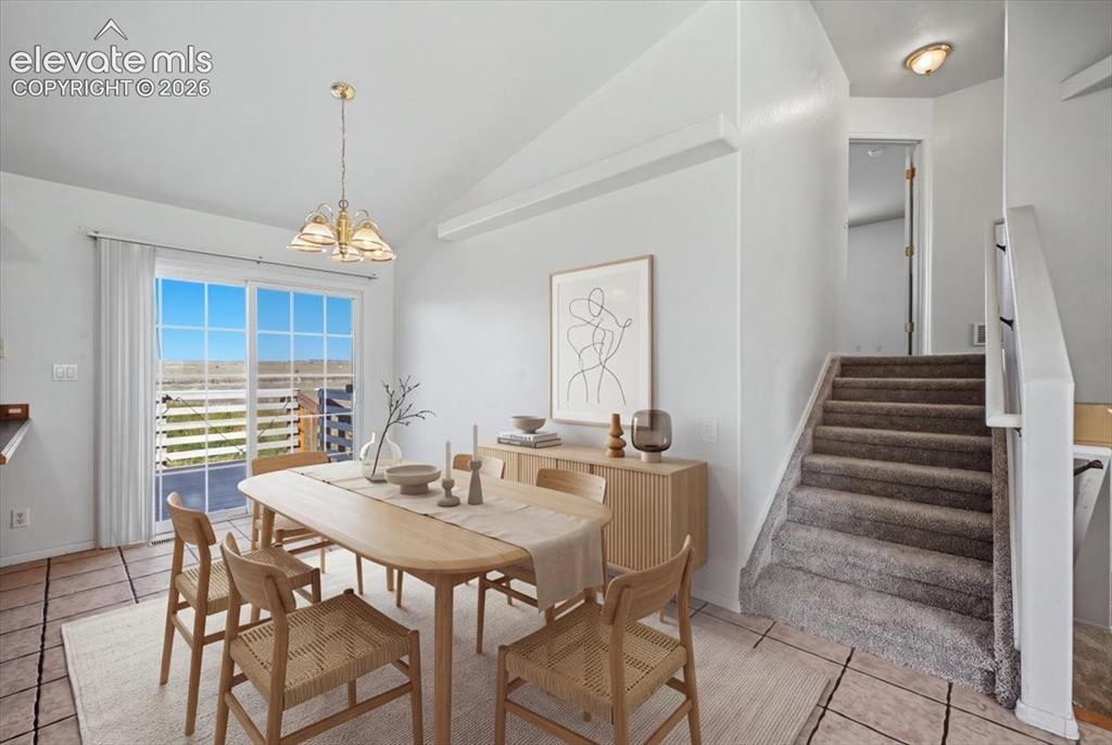 Image 10 of 46: Vaulted ceiling, sliding glass door, overhead light fixture, built-in stair