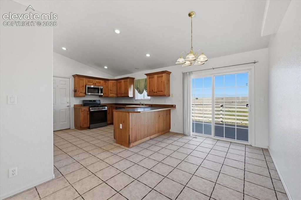 Image 11 of 46: Kitchen featuring wood cabinetry, stainless steel microwave, black range, a