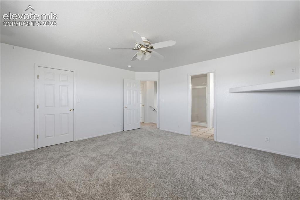 Image 14 of 46: Expansive room featuring plush carpeting, a ceiling fan with integrated lig