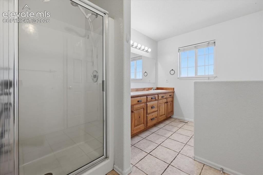 Image 17 of 46: Glass-enclosed shower with a chrome fixture