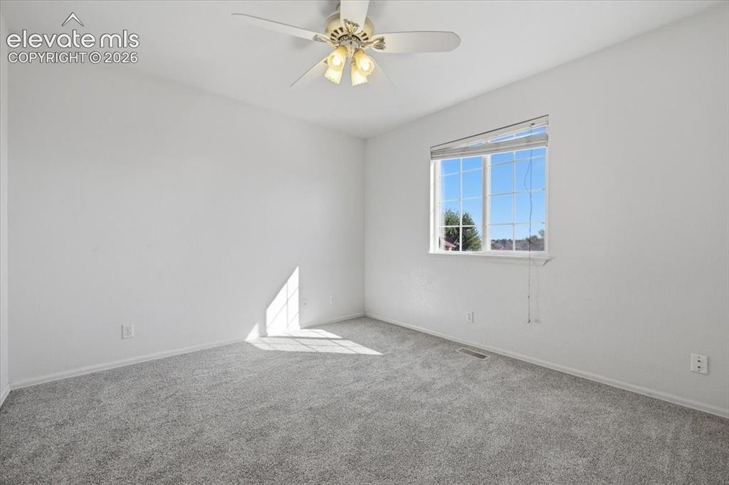 Image 22 of 46: Gray carpeting, light-colored walls, window with horizontal blinds, and a c