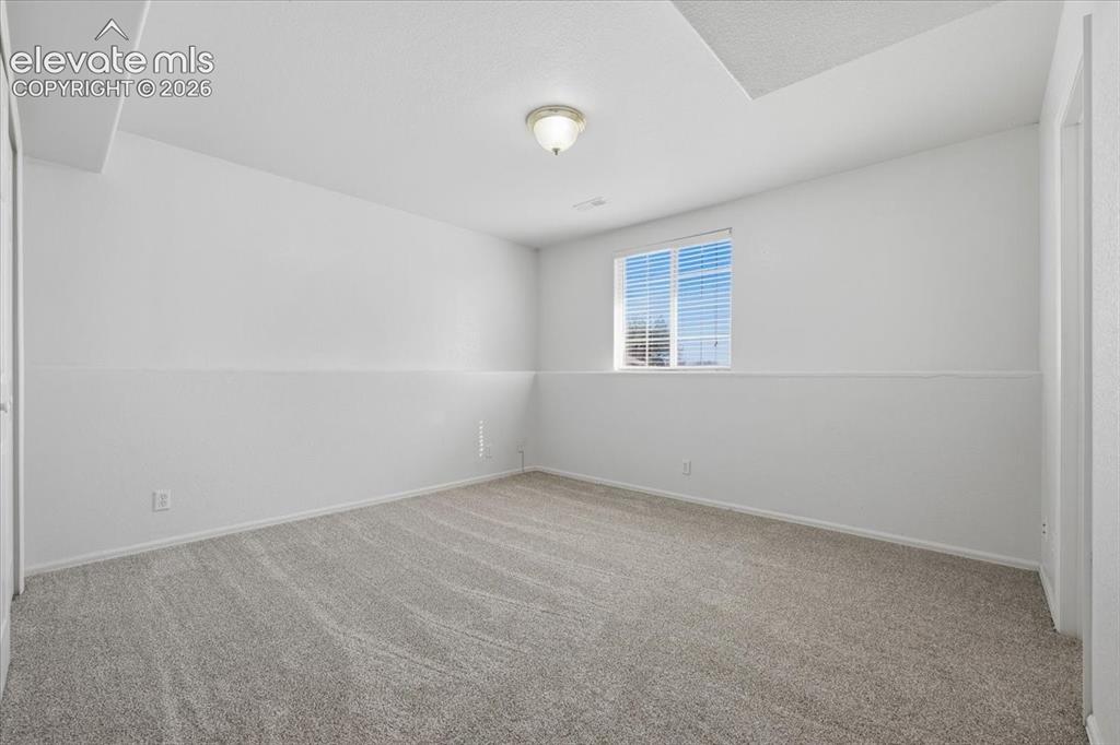 Image 27 of 46: Wall-to-wall carpeting, overhead light fixture, window with blinds, and whi