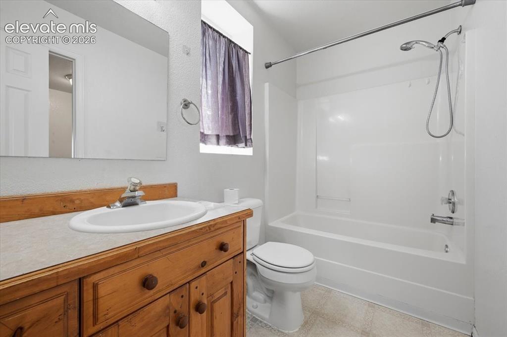 Image 29 of 46: Wood-finish vanity with an integrated sink and mirror