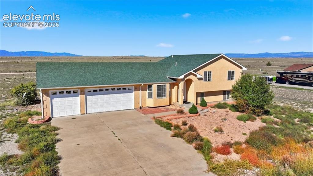 Image 3 of 46: Stucco exterior with a green shingle roof, arched entry, and an attached th