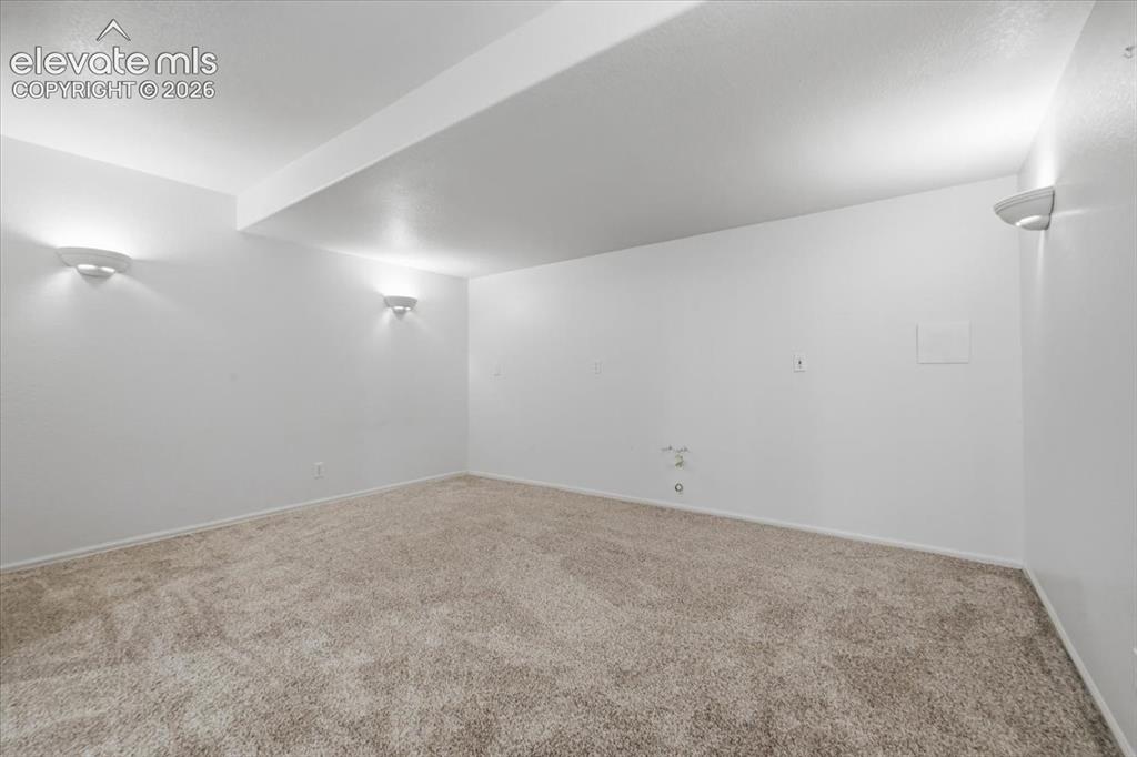 Image 34 of 46: Neutral-toned carpet flooring and white walls with integrated wall sconces