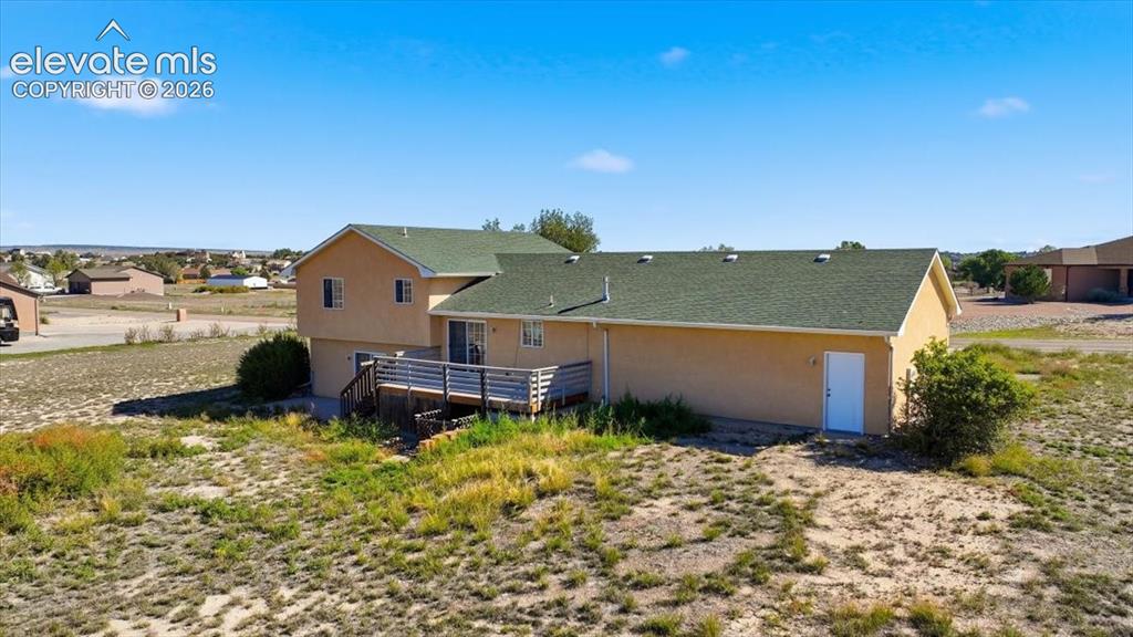 Image 41 of 46: Multi-level residence featuring a stucco exterior, a wood-finish deck, and