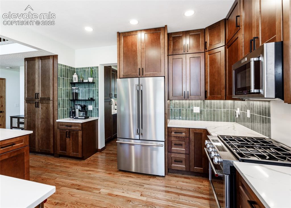 Image 14 of 38: Wood-finish flooring, stainless steel appliances, custom cabinetry, quartz 