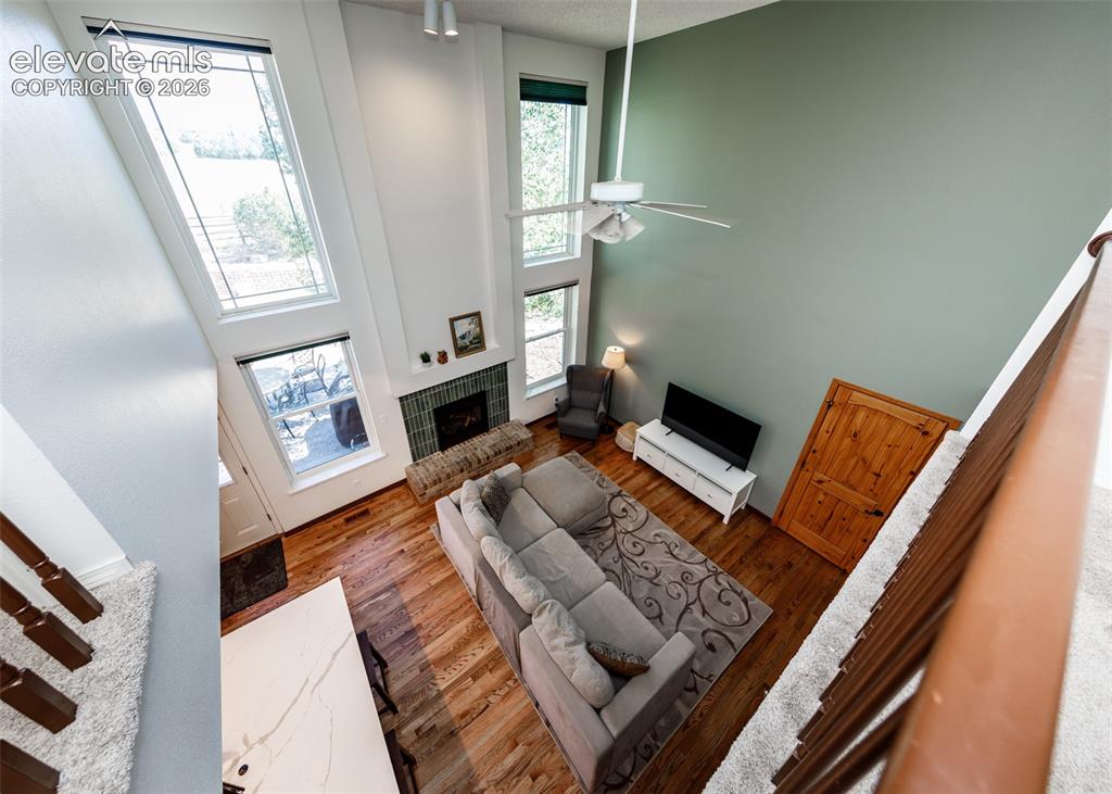 Image 17 of 38: Vaulted ceiling, hardwood flooring, fireplace with brick hearth, multiple t