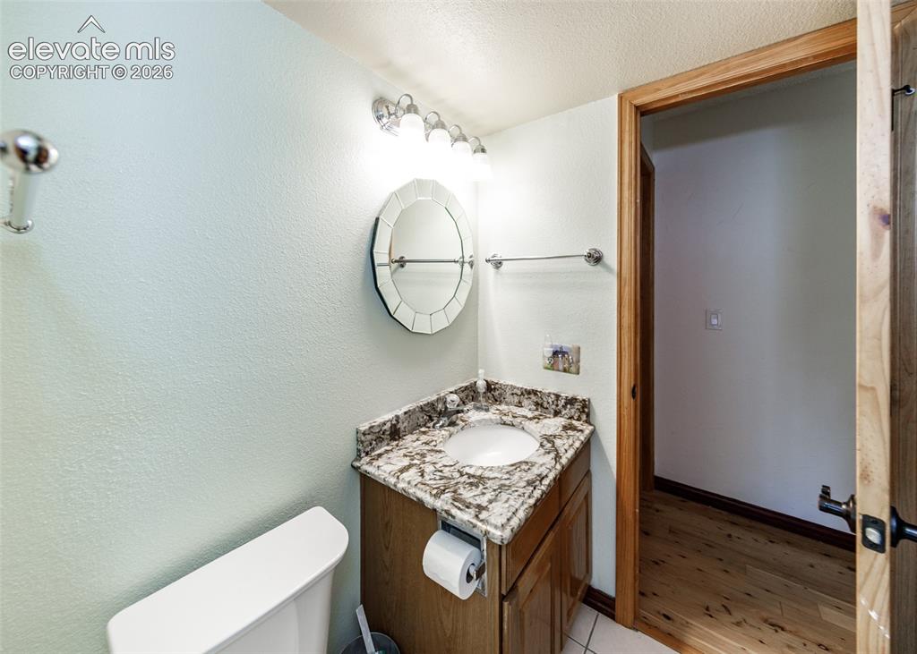 Image 19 of 38: Vanity with granite-style countertop, integrated sink, and wood cabinetry
