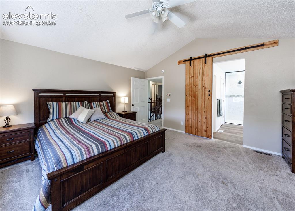 Image 21 of 38: Vaulted ceiling with a ceiling fan, light-toned wall paint, natural wood-fi