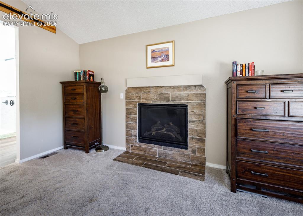 Image 22 of 38: Gas fireplace with a tile surround and hearth, featuring a neutral mantel