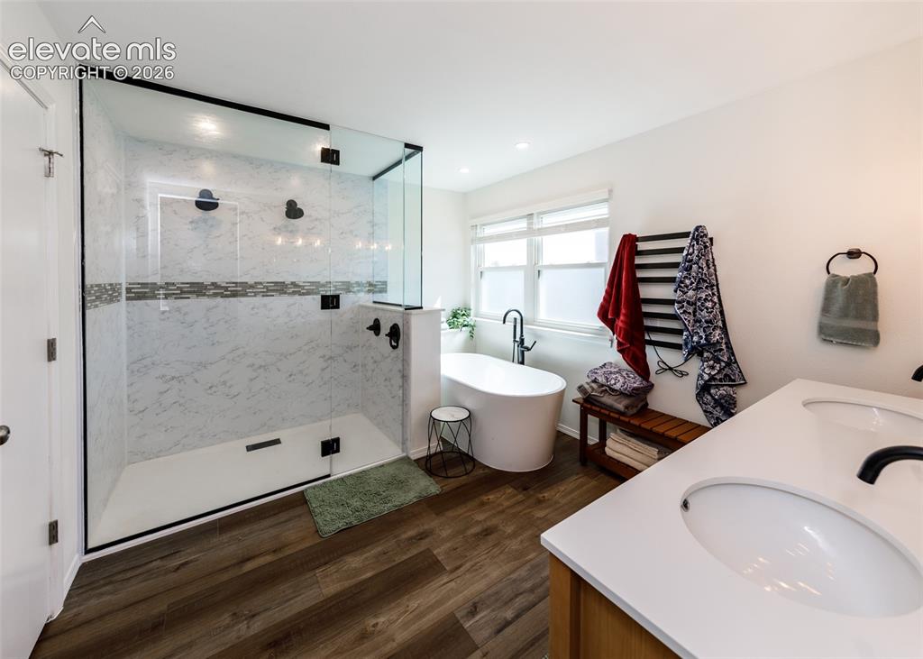 Image 23 of 38: Walk-in shower with clear glass enclosure and marble-look tile