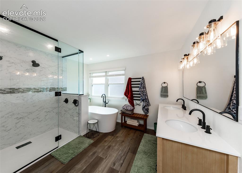 Image 24 of 38: Spacious bathroom featuring a glass-enclosed shower with tile surround, fre