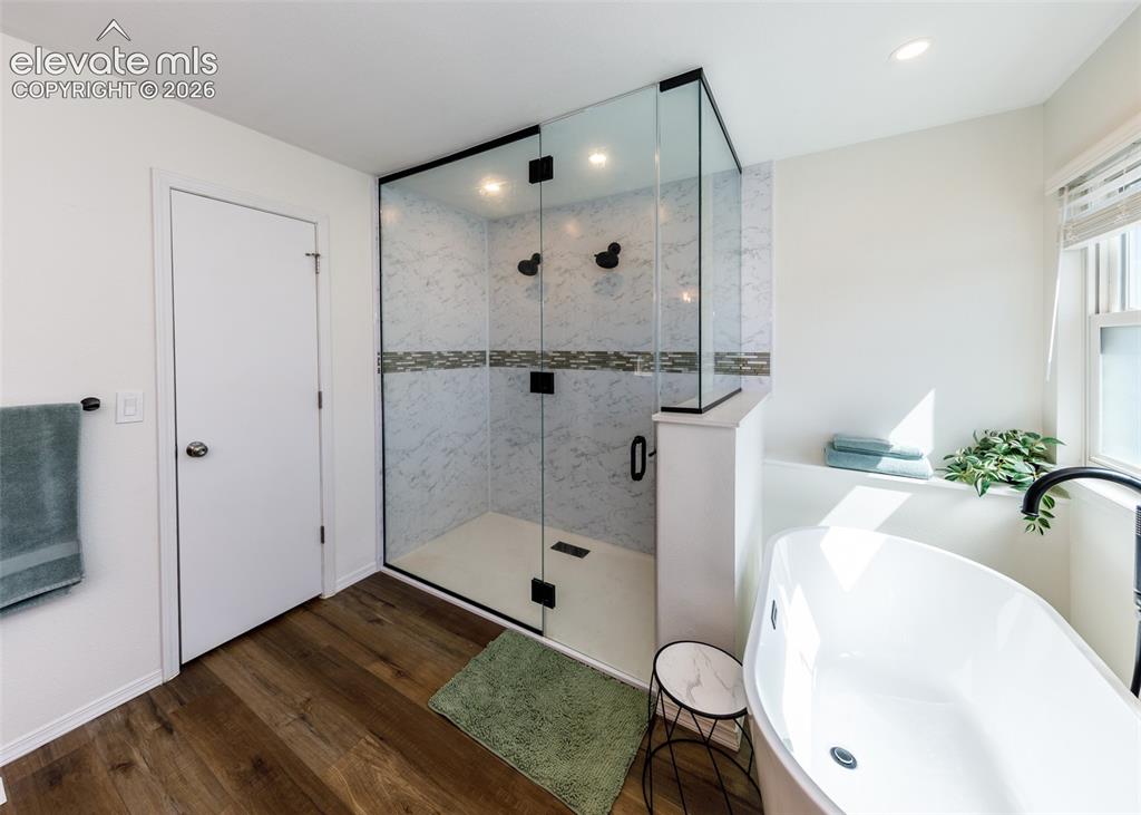 Image 25 of 38: Glass-enclosed shower with tiled walls and dark bronze fixtures