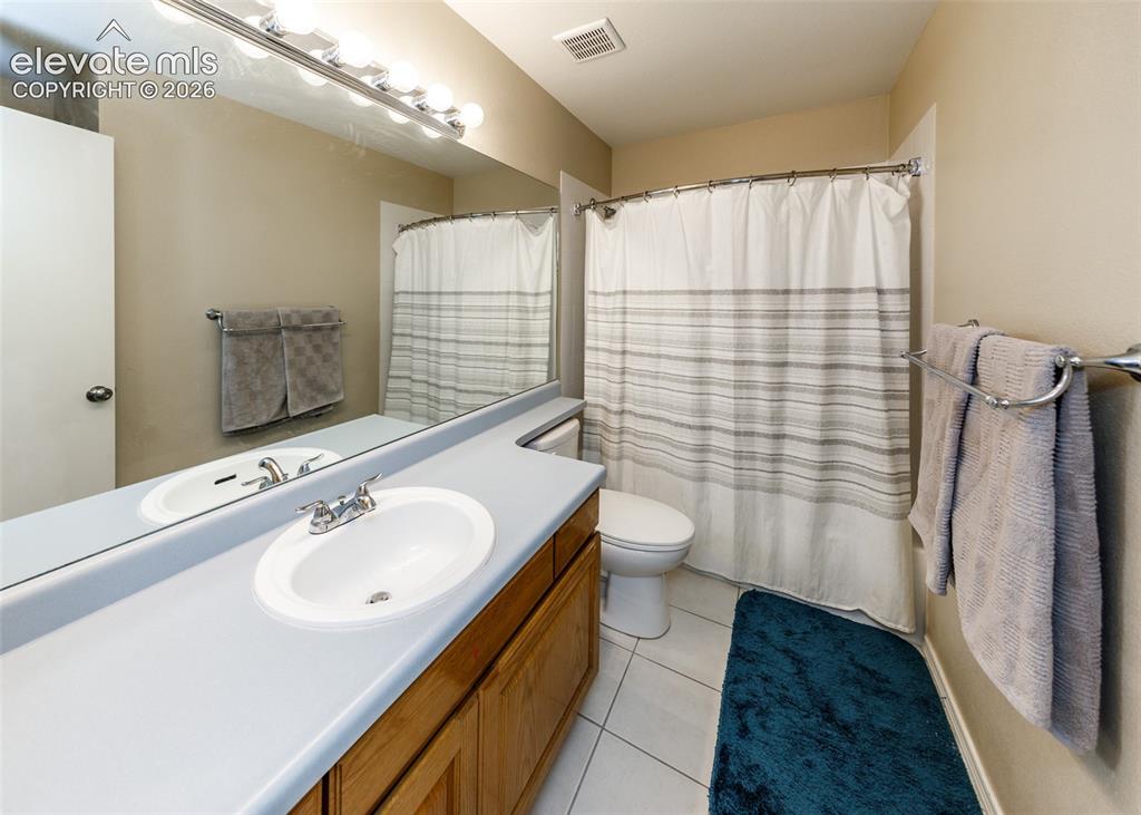 Image 28 of 38: Wood-finish vanity with an integrated basin, chrome faucet, and expansive w