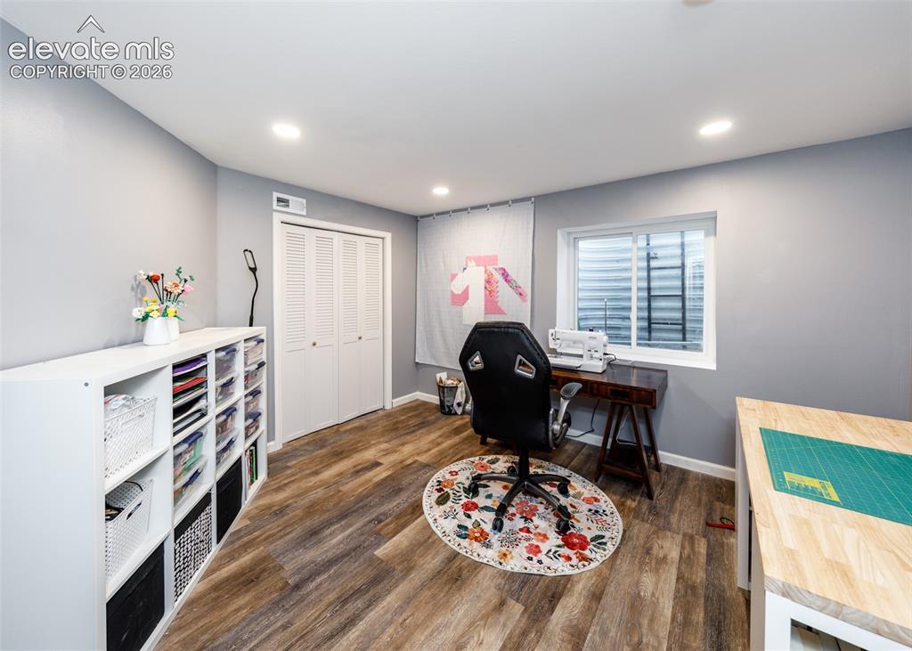 Image 34 of 38: Recessed lighting, wood-finish flooring, white louvered bifold doors, and a
