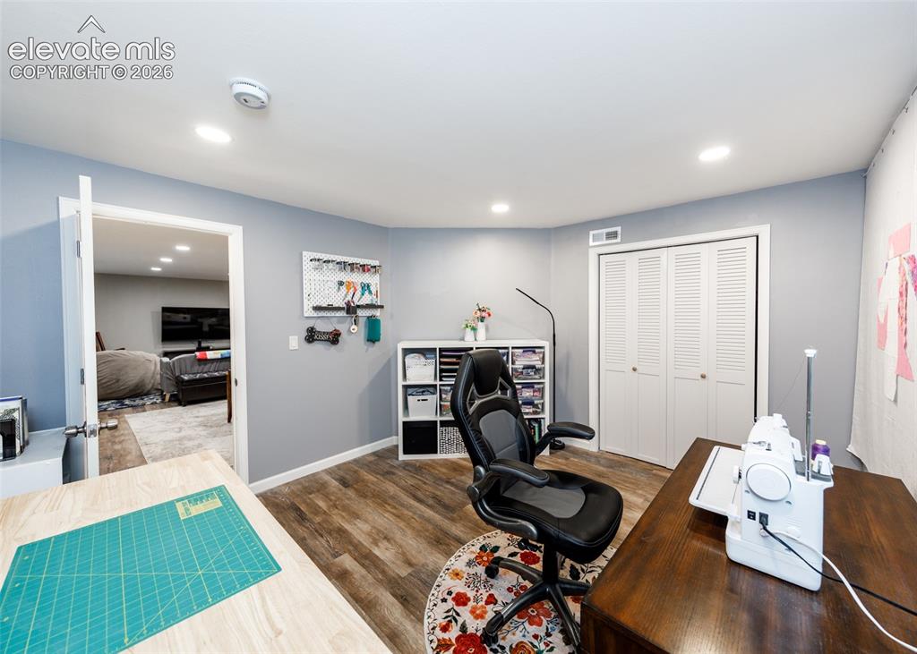 Image 35 of 38: Dedicated creative workspace featuring recessed lighting, wood-finish floor
