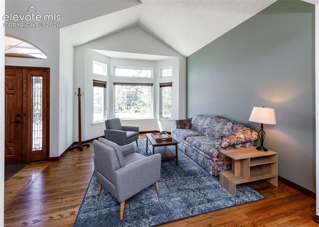 Image 7 of 38: Vaulted ceilings, wood-finish flooring, bay windows, leaded glass front doo