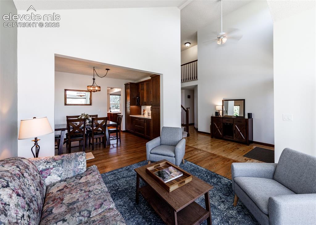 Image 8 of 38: Vaulted ceilings with a ceiling fan, wood-finish flooring, and a dining are