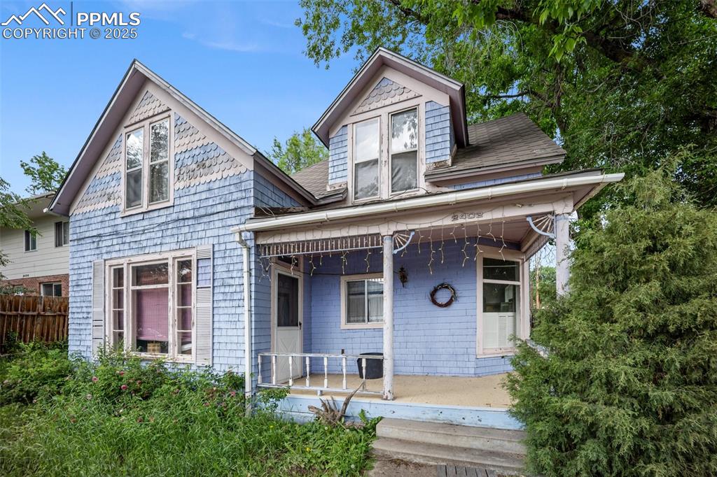 Caption: Victorian home featuring covered porch and roof with shingles