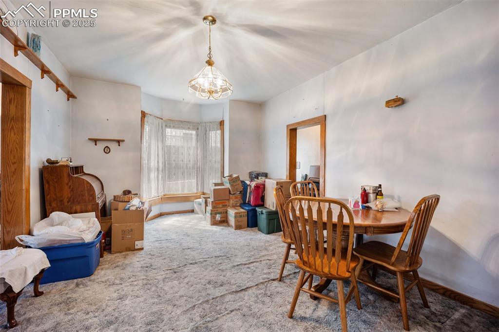 Image 11 of 48: Carpeted dining space with a chandelier