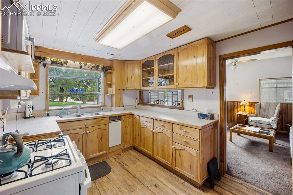Image 17 of 48: Kitchen featuring white gas range, open shelves, light wood-style floors, l